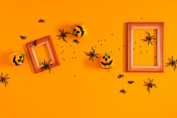 Halloween background. Flat lay. Top view of photo frame , Halloween decorations, пауки и тыквы on orange background. Halloween concept