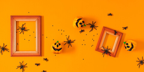 Halloween background. Flat lay. Top view of photo frame , Halloween decorations, пауки и тыквы on orange background. Halloween concept