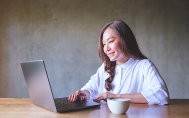 Wall Mural - portrait image of a young woman working on laptop computer