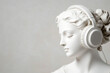 © carolina - Antique sculpture of a woman in headphonesstatue of a female with headphones in grey background/banner