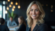 © Olha Havelia - A beautiful blonde woman in her late thirties, smiling and standing at the front of an office meeting room with team members sitting around a table. She is wearing business attire