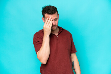 Wall Mural - Young caucasian handsome man isolated on blue background with headache