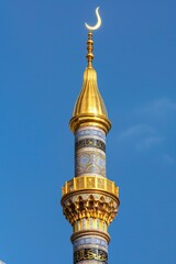 Wall Mural - A historic clock tower with a distinctive crescent shape on its roof