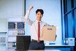 © Nuttapong punna - young  Asian man office worker celebrating her resignation, carrying her personal stuff. leaving job, changing or company