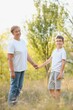 © Serhii - A beautiful grandmother spends time with her grandson in nature at sunset