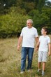 © Serhii - Grandfather and grandson walking at sunset