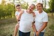 © Serhii - Grandson, grandfather and grandmother sitting on grass having fun outdoors in park at sunset