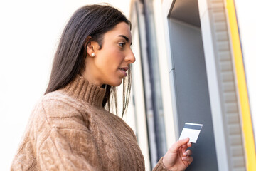 Wall Mural - Young woman holding a credit card at outdoors