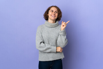 Young English woman isolated on purple background pointing up a great idea