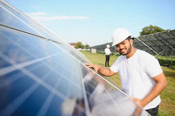 Wall Mural - Portrait of a young Indian male engineer working in a field of solar panels