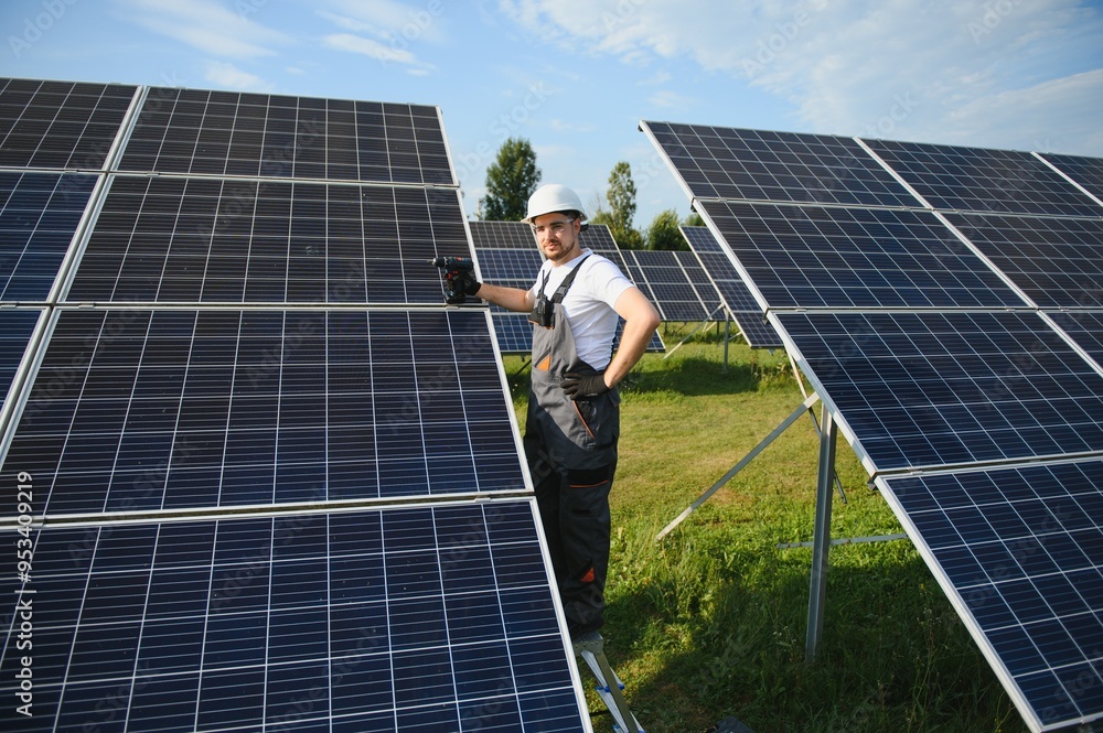 Side view of male worker installing solar modules and support ...
