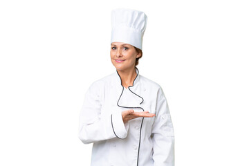 Wall Mural - Middle-aged chef woman over isolated background presenting an idea while looking smiling towards