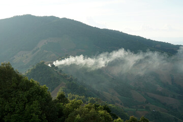 The landscape of the mountain range with the smoke in a mountain village.