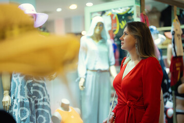 A woman looks at a display of clothes in a store.