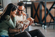 © NDABCREATIVITY - Smiling mother and father holding their newborn baby daughter at home