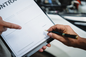 Wall Mural - Car seller agent signs a car insurance agreement with salesman. The document outlines vehicle policy, premium, rental terms, with contract paper finalized using car insurance claim mobile phone.