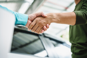 Wall Mural - Car seller agent signs a car insurance agreement with salesman. The document outlines vehicle policy, premium, rental terms, with contract paper finalized using car insurance claim mobile phone.