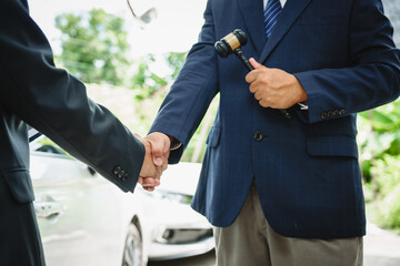 Wall Mural - Two Asian individuals discuss a car insurance claim with an agent in front of a damaged vehicle. They review documents, discuss the policy, and address the crash and repair costs.