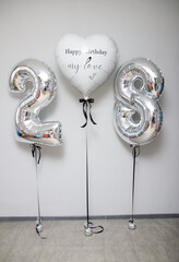 silver numbers 28 and a large heart balloon