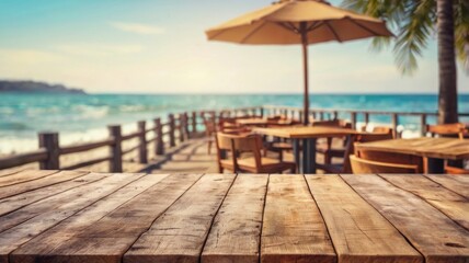 Empty wooden tabletop overlooking a beachfront restaurant with a view of the ocean