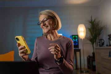 Poster - Mature senior woman sit at home and use mobile phone
