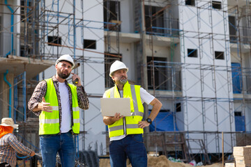 Architect and contractor working on building in construction site. Two Professional Architects Engineer Working on Personal laptop computer at house construction site