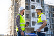 © NVB Stocker - Architect and contractor working on building in construction site. Two Professional Architects Engineer Working on Personal laptop computer at house construction site