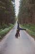 © Fauren - Acrobatic woman in black leggings and plaid shirt performs a cartwheel on a forest path in the middle of a deep forest. Coordination and agility training