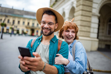 Wall Mural - Young couple, on a vacation, exploring the new city and using their phone as gps to help them not get lost.