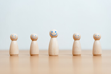 group, recruitment, strategy, leader, team, protection, community, competitive, cooperation, ceo. A group of wooden figurines are lined up, with one of them smiling.