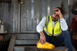 © Supachai - Asian man worker feeling tired while sitting at construction site.