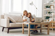 © SHOTPRIME STUDIO - Mother and daughter bonding on the couch while using a laptop, enjoying quality time and online activities together