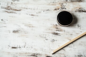 Wall Mural - White Wooden Background with Black Lid and Stick