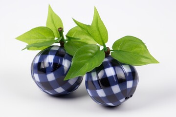 Two juicy blueberries surrounded by lush green leaves on a white checkered surface