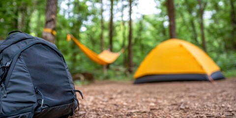 A tidy campsite with a tent close by, a hammock slung between trees, and a backpack.