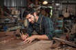 © surachetkhamsuk - Luthier making a peghead of classical guitar