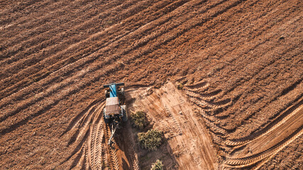 Aerial top view tractor plowing a field , preparing the land for a wheat planting operation.