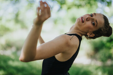 Lovely girl dancing in nature, female dancer performing modern dance in a green scenic forest background