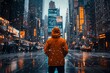 © Peeradontax - A solitary figure stands in the middle of a bustling city street during a snowfall, their bright orange jacket contrasting with the dark, wet streets and the glowing lights of towering skyscrapers.