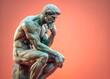 © Diana - Classic statue of a thinking man in a traditional contemplative pose, set against a warm orange background. Symbolizes philosophy, wisdom, and deep thought. Сopy space