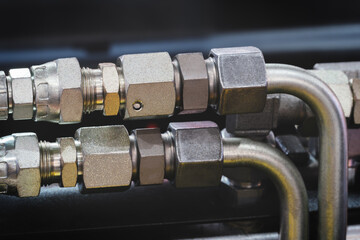 Poster - A series of pipes are shown in a close up. The pipes are silver and appear to be connected to a larger system. Concept of complexity and organization
