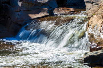 Photograph of water flowing in Adelong creek near the Adelong Falls Gold Mine ruins in the Snowy Mountains in New South Wales in Australia.