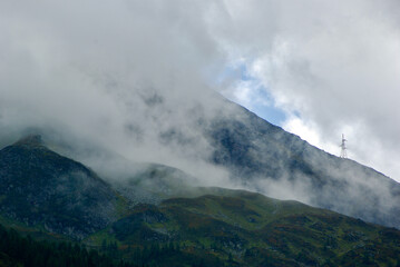 Wall Mural - view of an amazing mountain landscape on a hazy day with gray clouds and fog over the peaks in autum