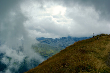 Wall Mural - mountain top with a wooden bench with a view of an amazing landscape on a hazy day with gray clouds 