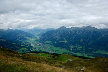 Wall Mural - view of an amazing mountain landscape with a village in the valley on a hazy day with gray clouds an