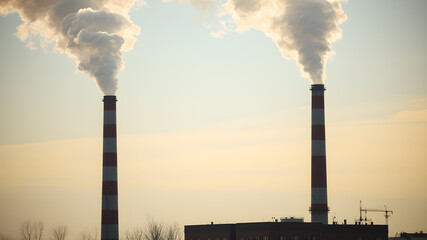 Smoke emissions from two factory chimneys causing air pollution. Generative AI