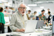 © Pavel Iarunichev - Older gentleman with glasses sits at a crowded desk, his expression reflecting surprise as he types on a laptop.