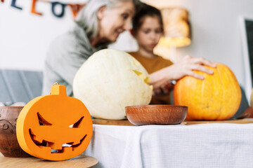 Wall Mural - Family carving pumpkins for halloween celebration at home, selective focus