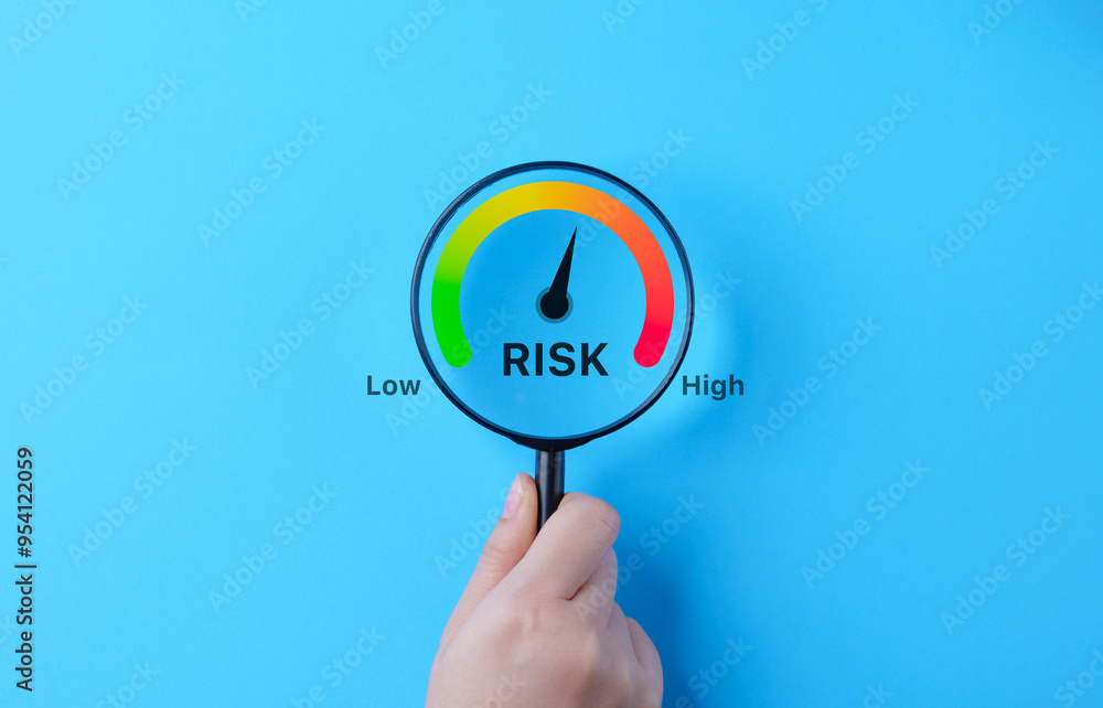 Business Risk Gauge with Low to High Indicator. A hand holding ...