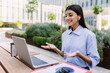 © Xavier Lorenzo - Happy young woman using laptop computer, having a video call outside his office building or campus college